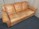 A three-seater tan leather sofa with broad, cushioned armrests W180x94D 44493