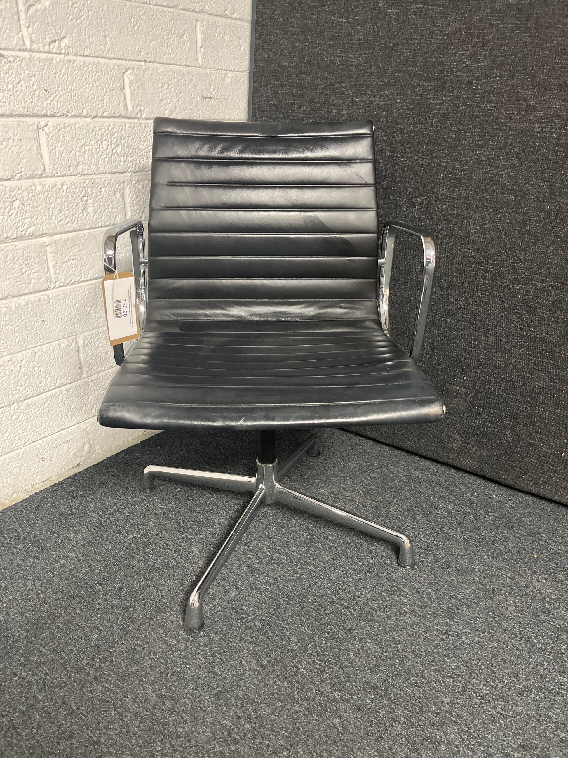 Eames style black leather low back swivel chair with polished chrome base on pads or castors