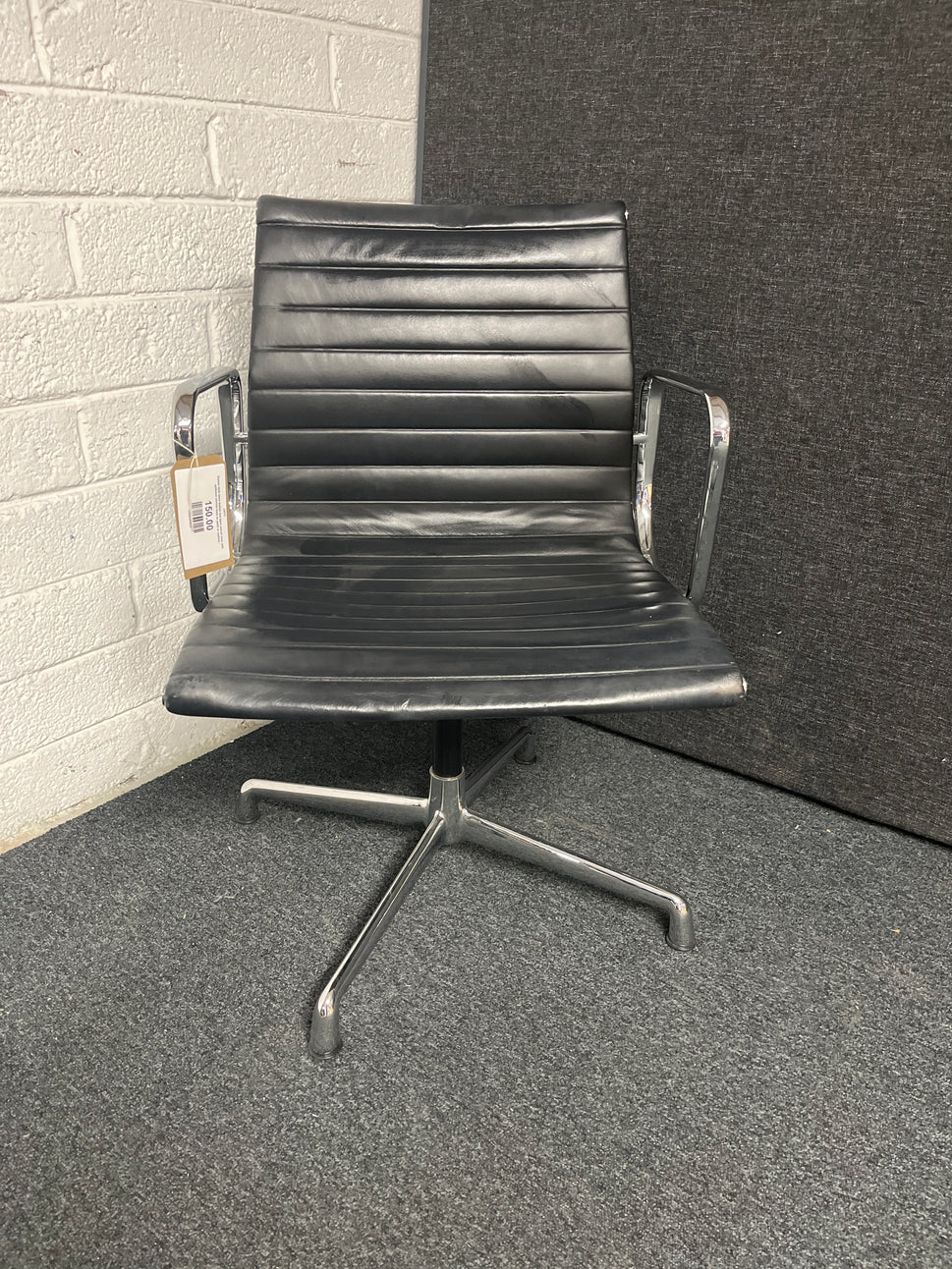 Eames style black leather low back swivel chair with polished chrome base on pads or castors