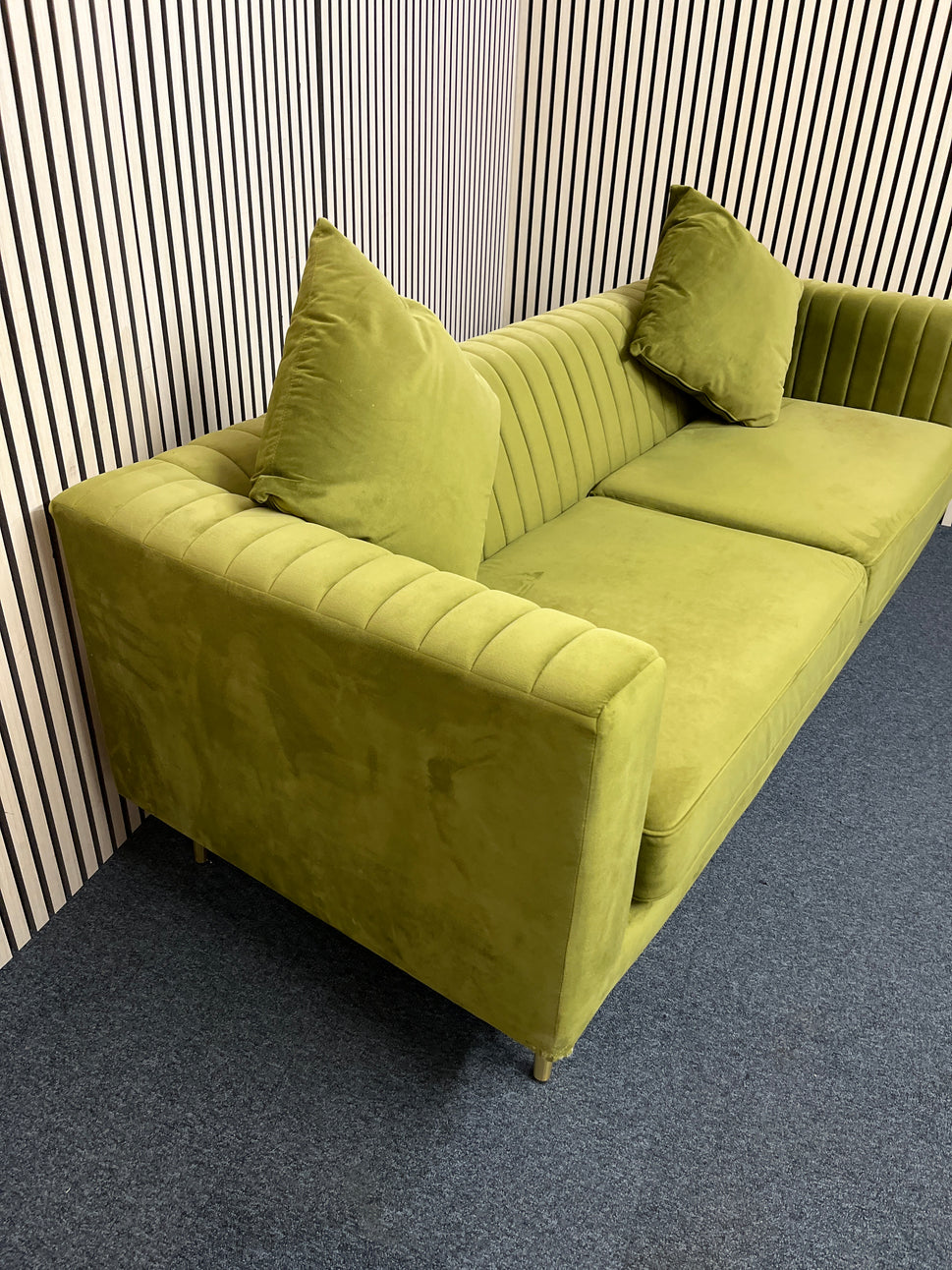 Modern olive green velvet sofa with vertical channel tufting, 2 seat cushions and slim black legs assencted with gold tips( W x 197 L x 81 H x 73 cm)