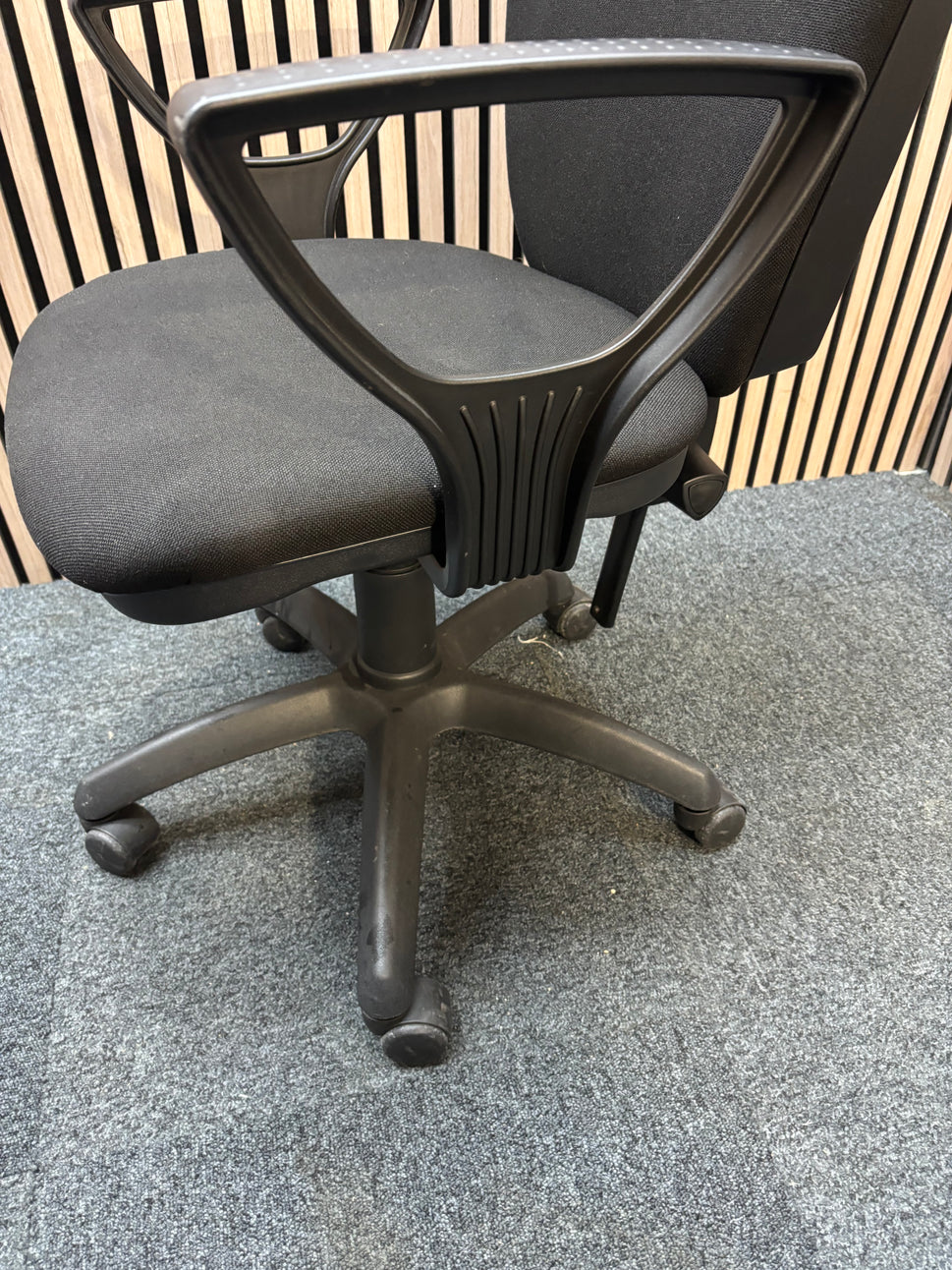 Black fabric swivel chair with black plastic fixed arms and 5 star swivel base