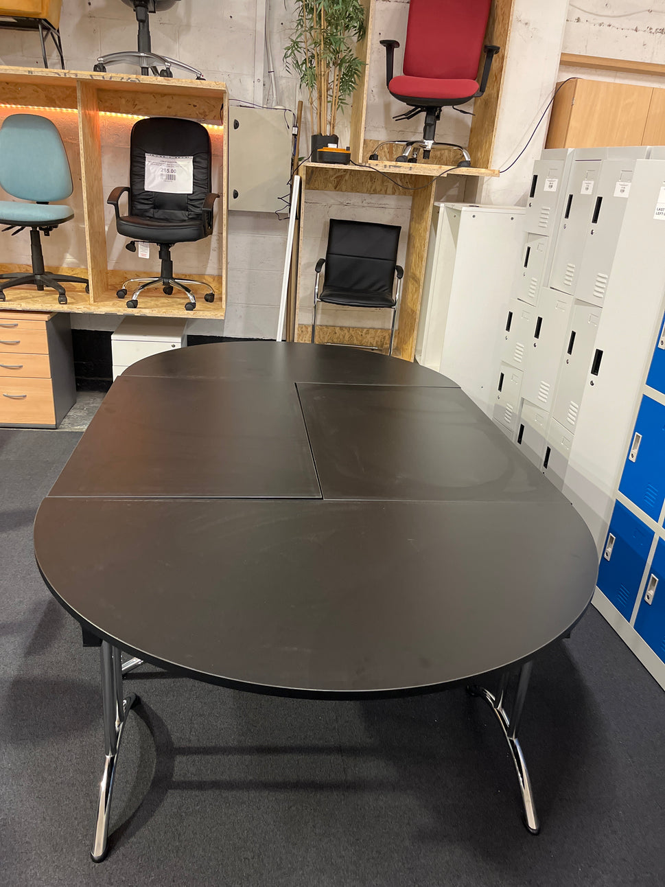 Large black oval shaped boardroom table (length 2.8 m width 1.6 m) comprised of 2 black semi-circular foldable desks and 2 black straight foldable desks