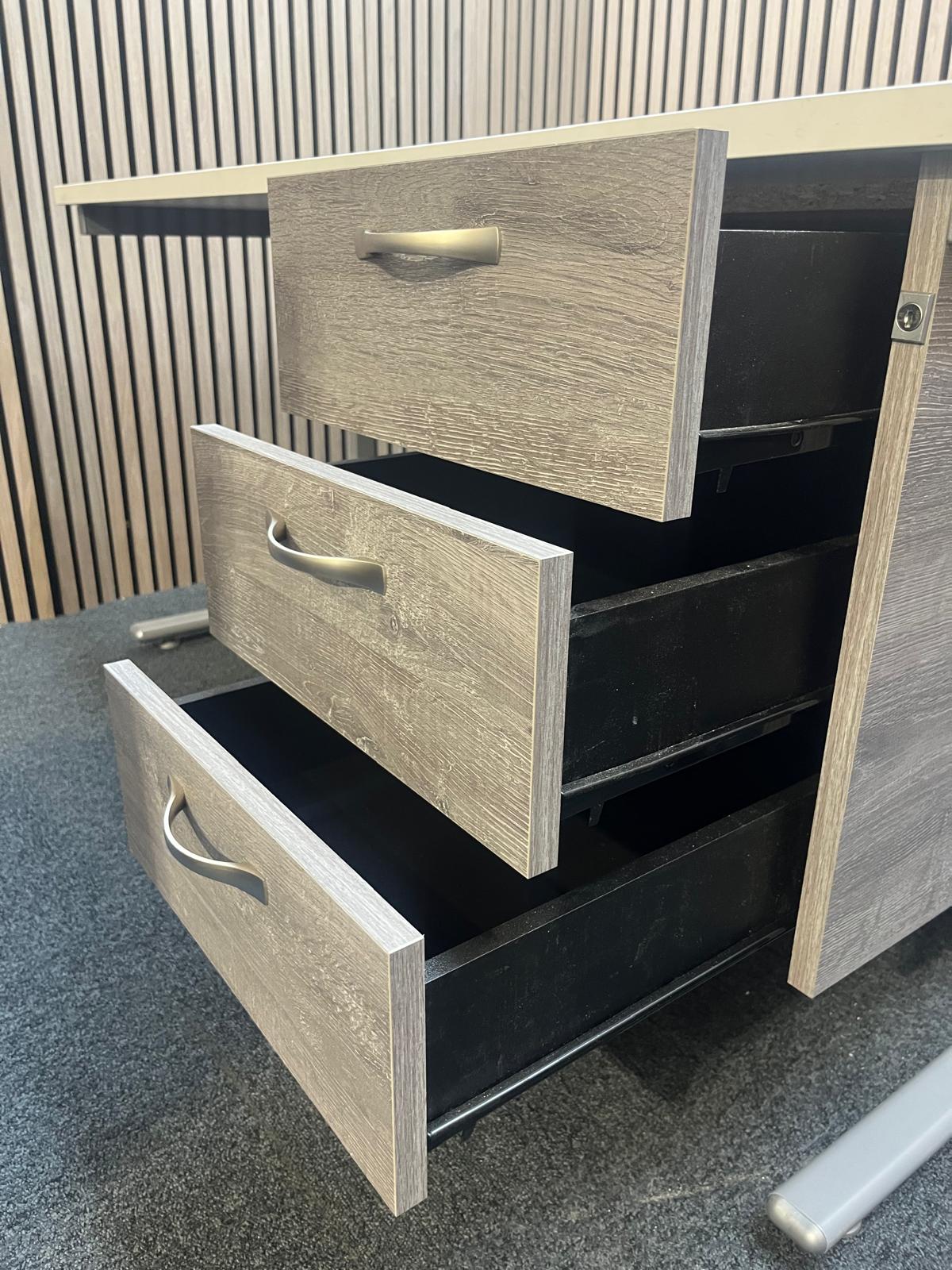 White cantilever framed 1400 x 800 desk with grey oak fixed pedestal and modesty panel