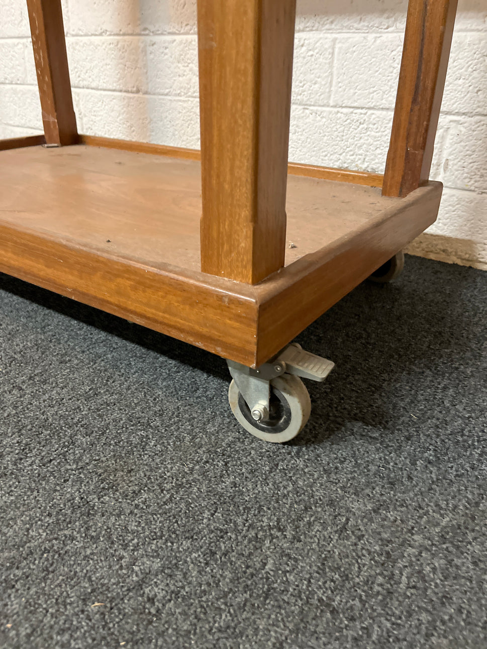 Stained pine high table with circular designs on castors (H 92 x W 90 x D 55 cm) 1325