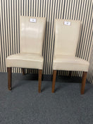 Pair of cream faux leather dining chair with dark wood legs. 44698
