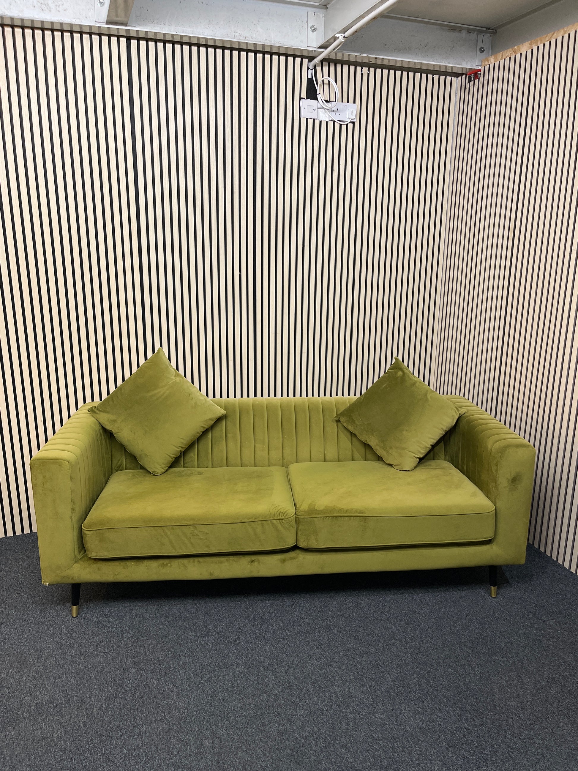 Modern olive green velvet sofa with vertical channel tufting, 2 seat cushions and slim black legs assencted with gold tips( W x 197 L x 81 H x 73 cm)