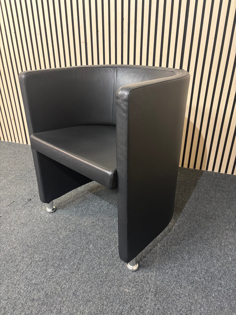 Dark leather curved back tub chair