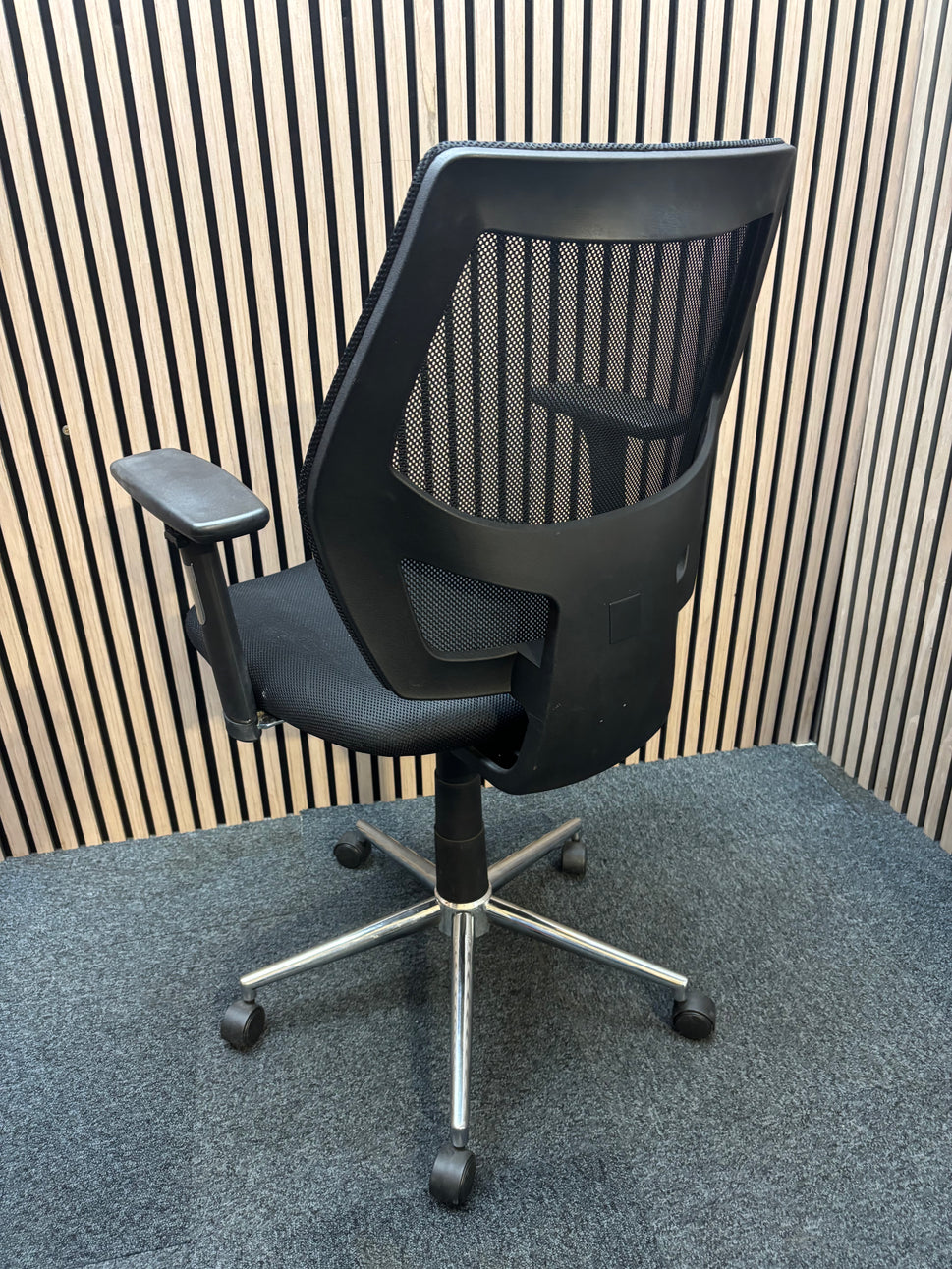 Black mesh back second hand swivel chair with adjustable arms and black fabric seat