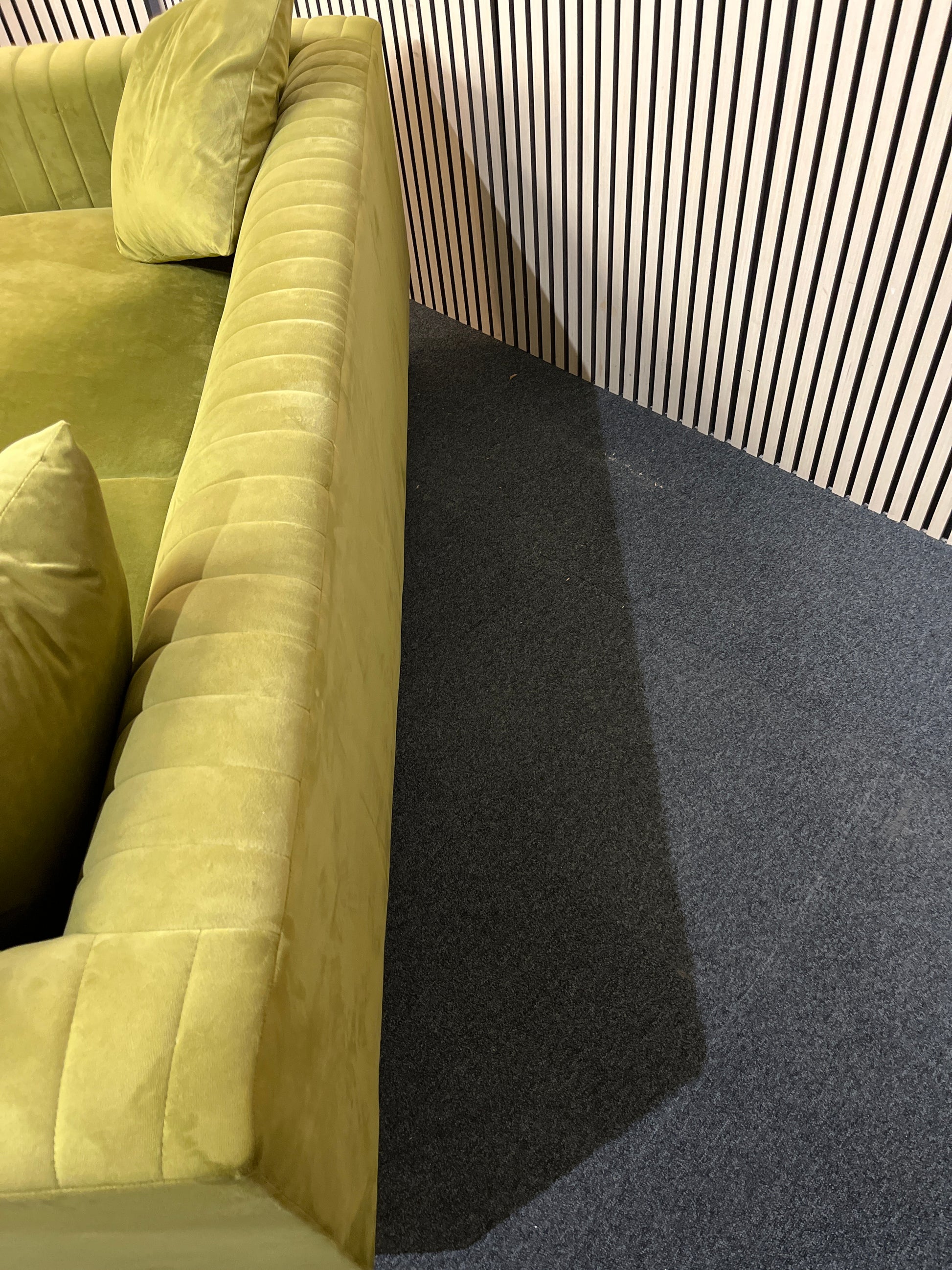 Modern olive green velvet sofa with vertical channel tufting, 2 seat cushions and slim black legs assencted with gold tips( W x 197 L x 81 H x 73 cm)