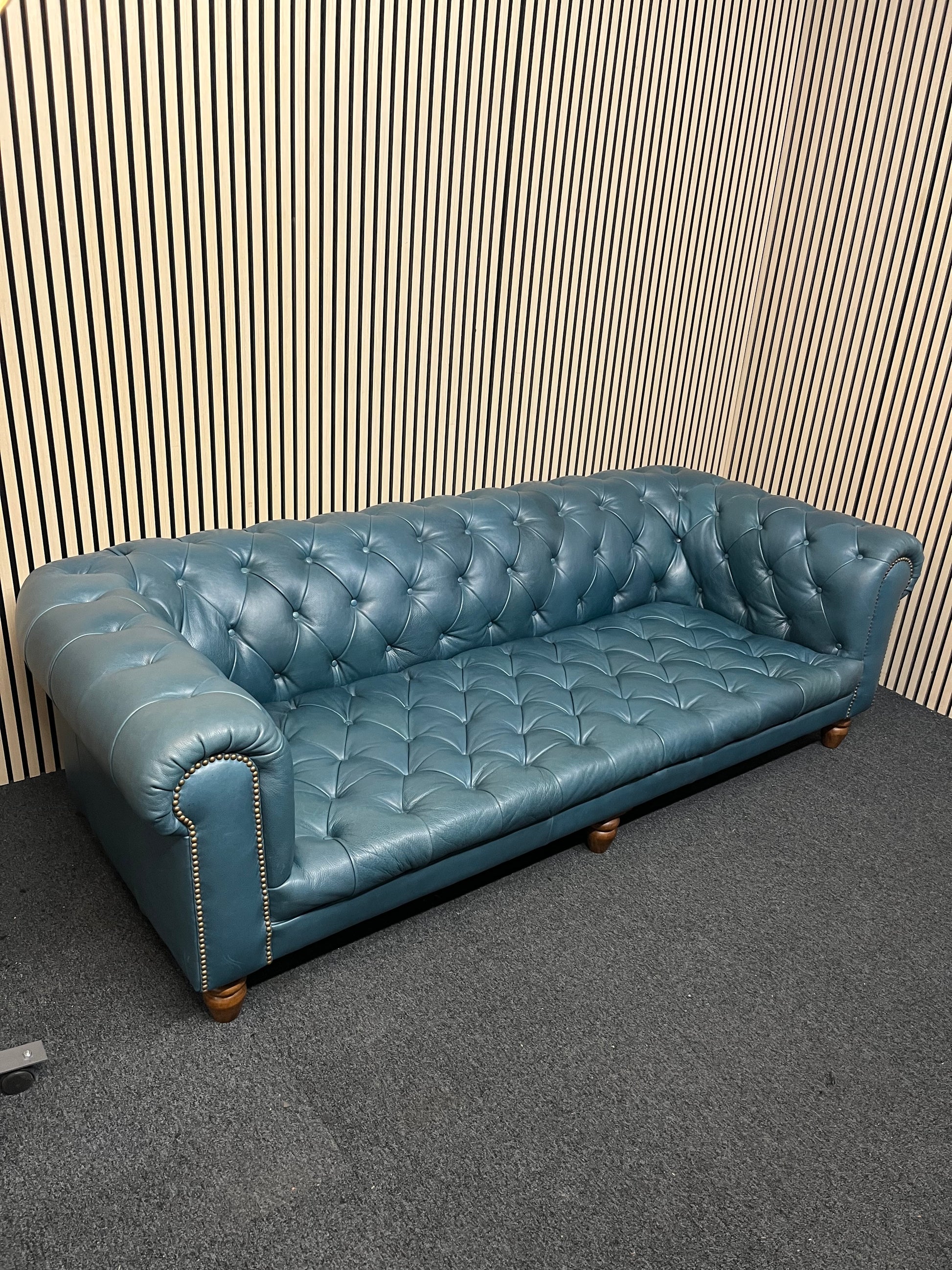 3 seater Chesterfield-style leather sofa in deep teal leather with tufted upholstery, rolled arms, and wooden legs accented by brass nailhead trim (width 230 cm) 1425