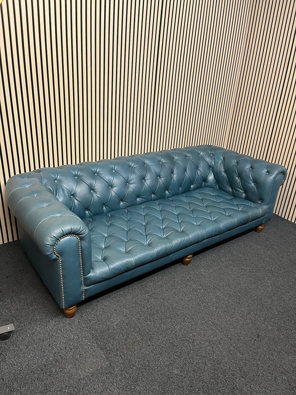 3 seater Chesterfield-style leather sofa in deep teal leather with tufted upholstery, rolled arms, and wooden legs accented by brass nailhead trim (width 230 cm) 1425