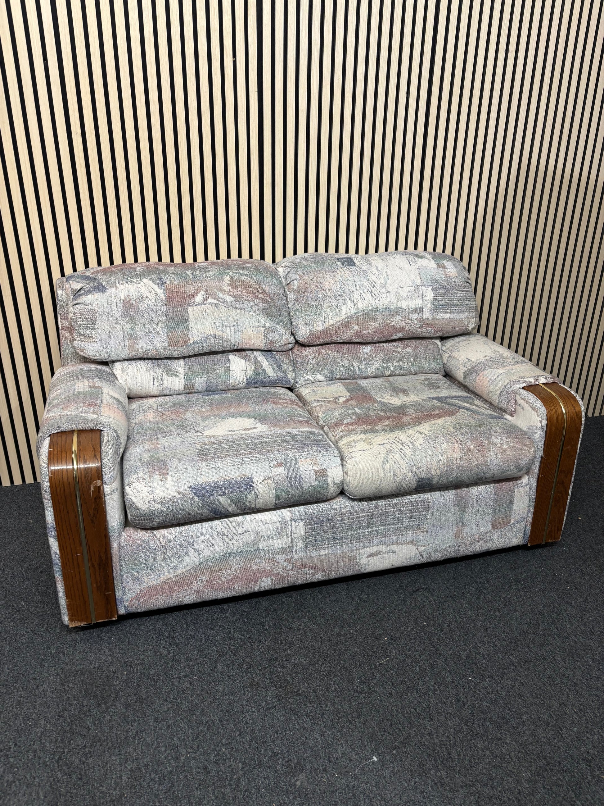 Patterned two-seater sofa with wooden arm accents