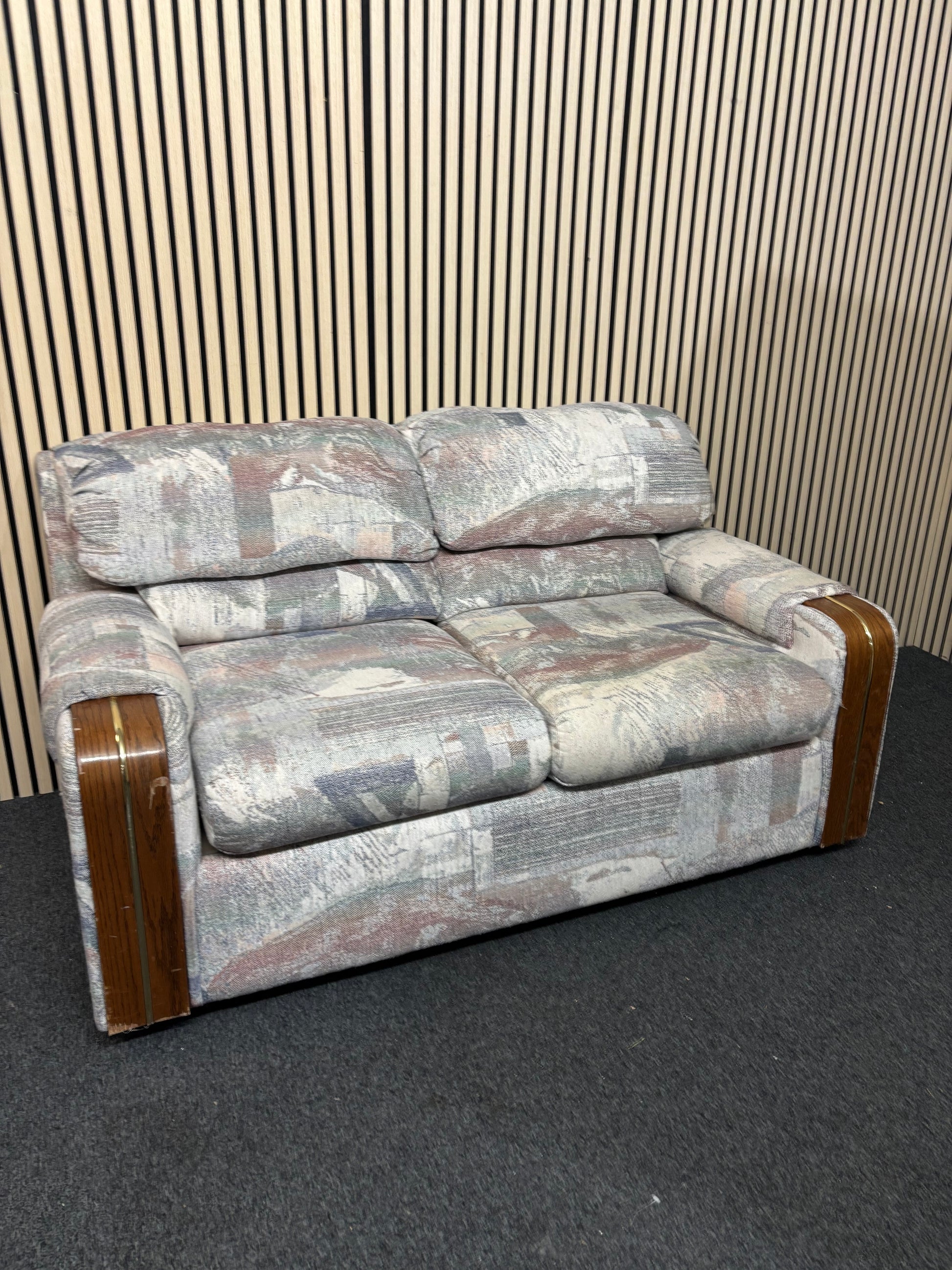 Patterned two-seater sofa with wooden arm accents