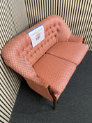 Two-seater sofa with pink geometric pattern and tufted backrest with slight wear to arm on LHS, solid wood frame. Ideal for