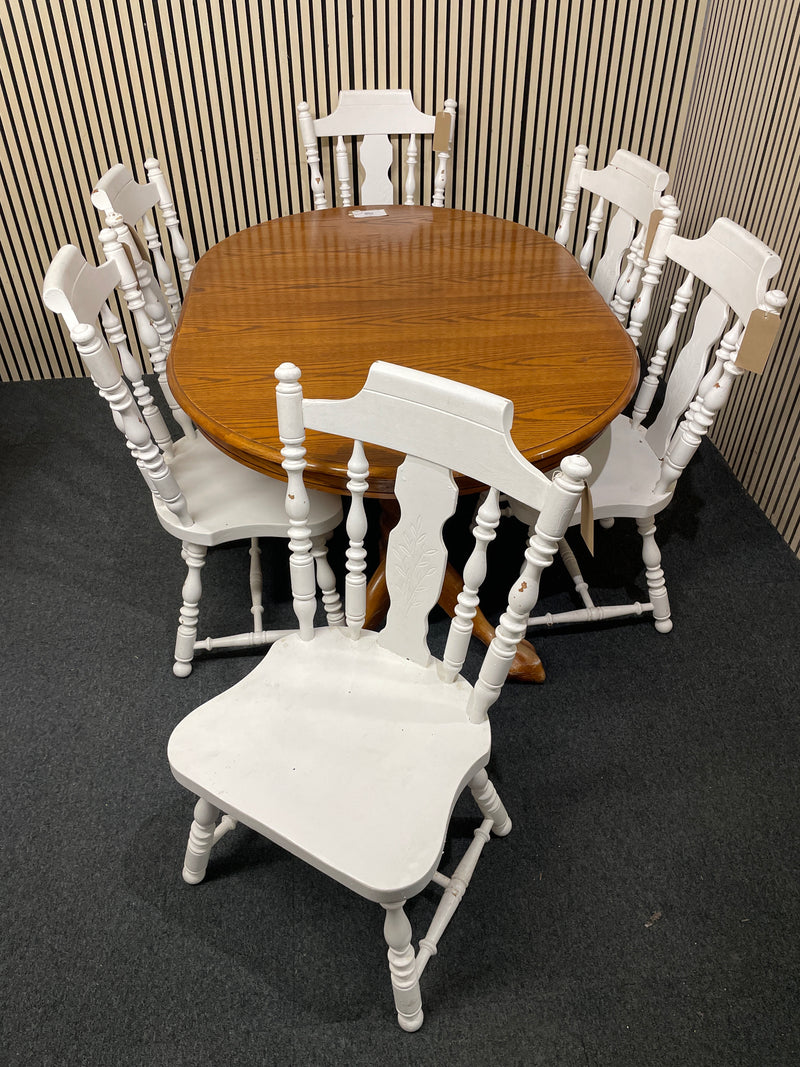 Oval wood dining table with six white spindle back chairs.  44515