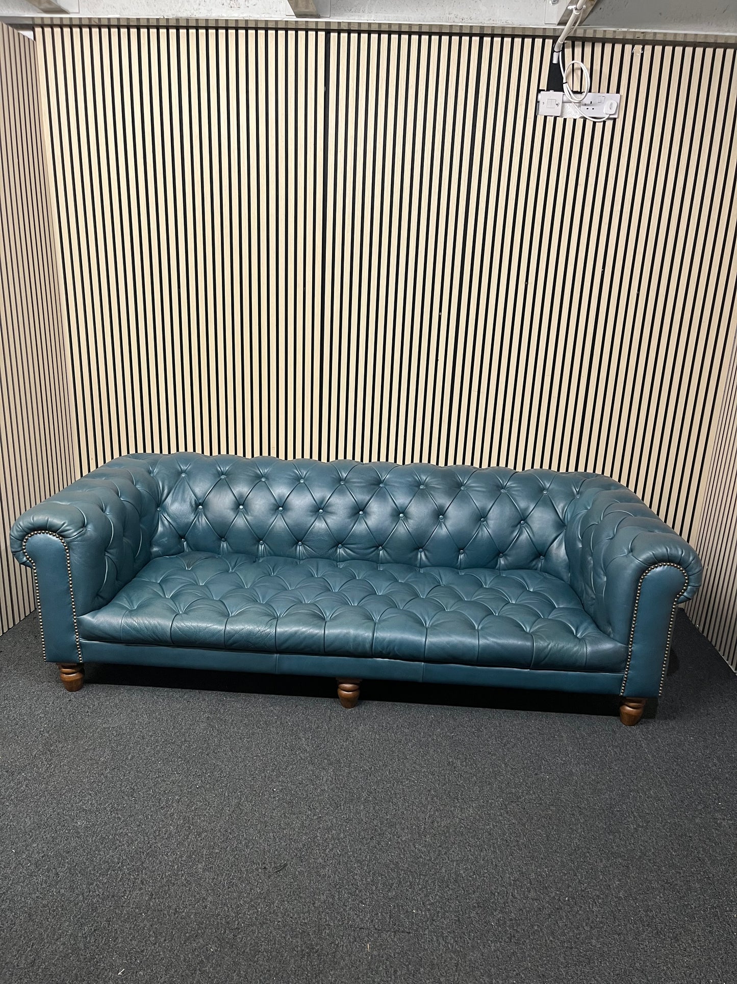 3 seater Chesterfield-style leather sofa in deep teal leather with tufted upholstery, rolled arms, and wooden legs accented by brass nailhead trim (width 230 cm) 1425