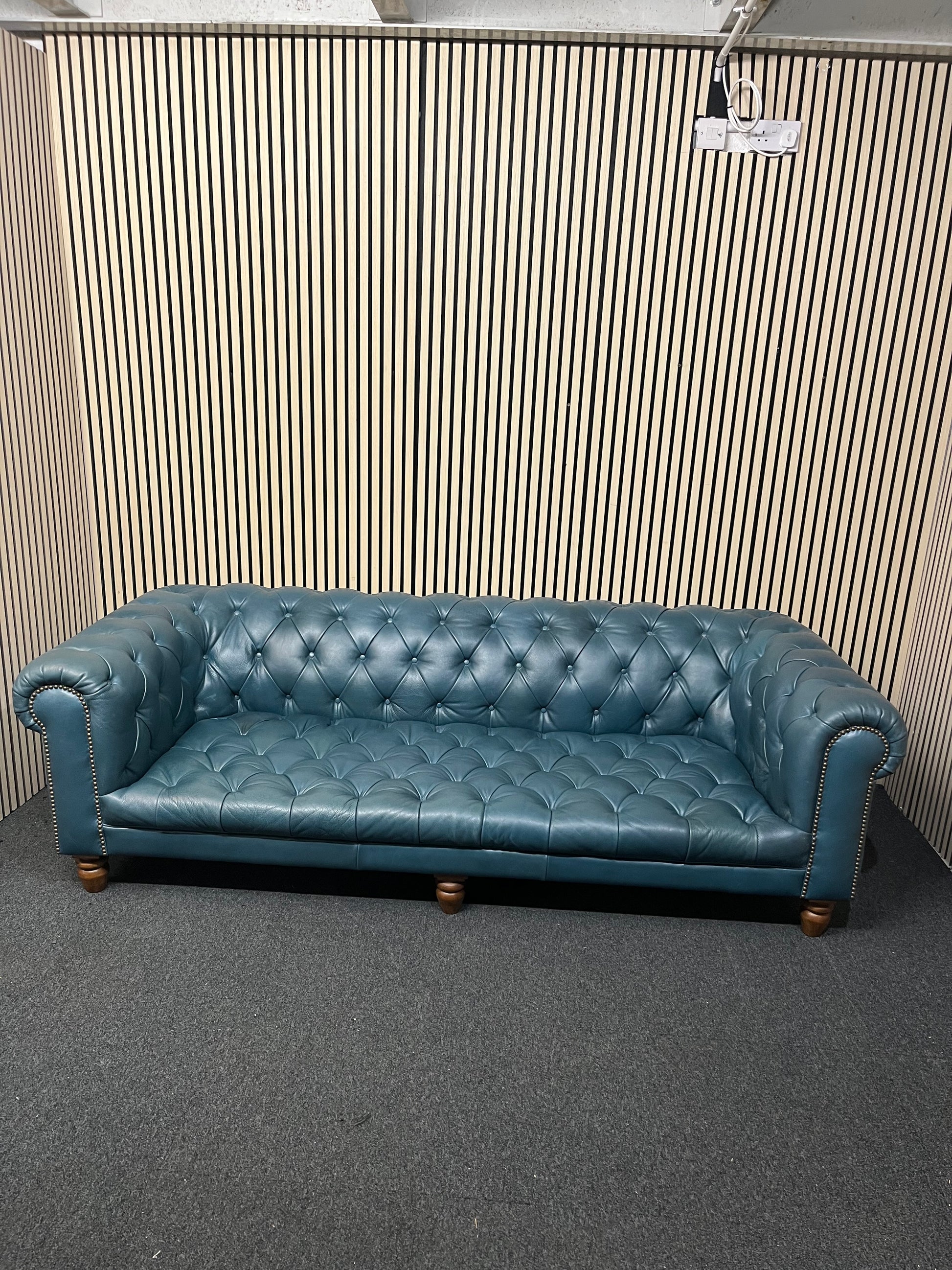 3 seater Chesterfield-style leather sofa in deep teal leather with tufted upholstery, rolled arms, and wooden legs accented by brass nailhead trim (width 230 cm) 1425