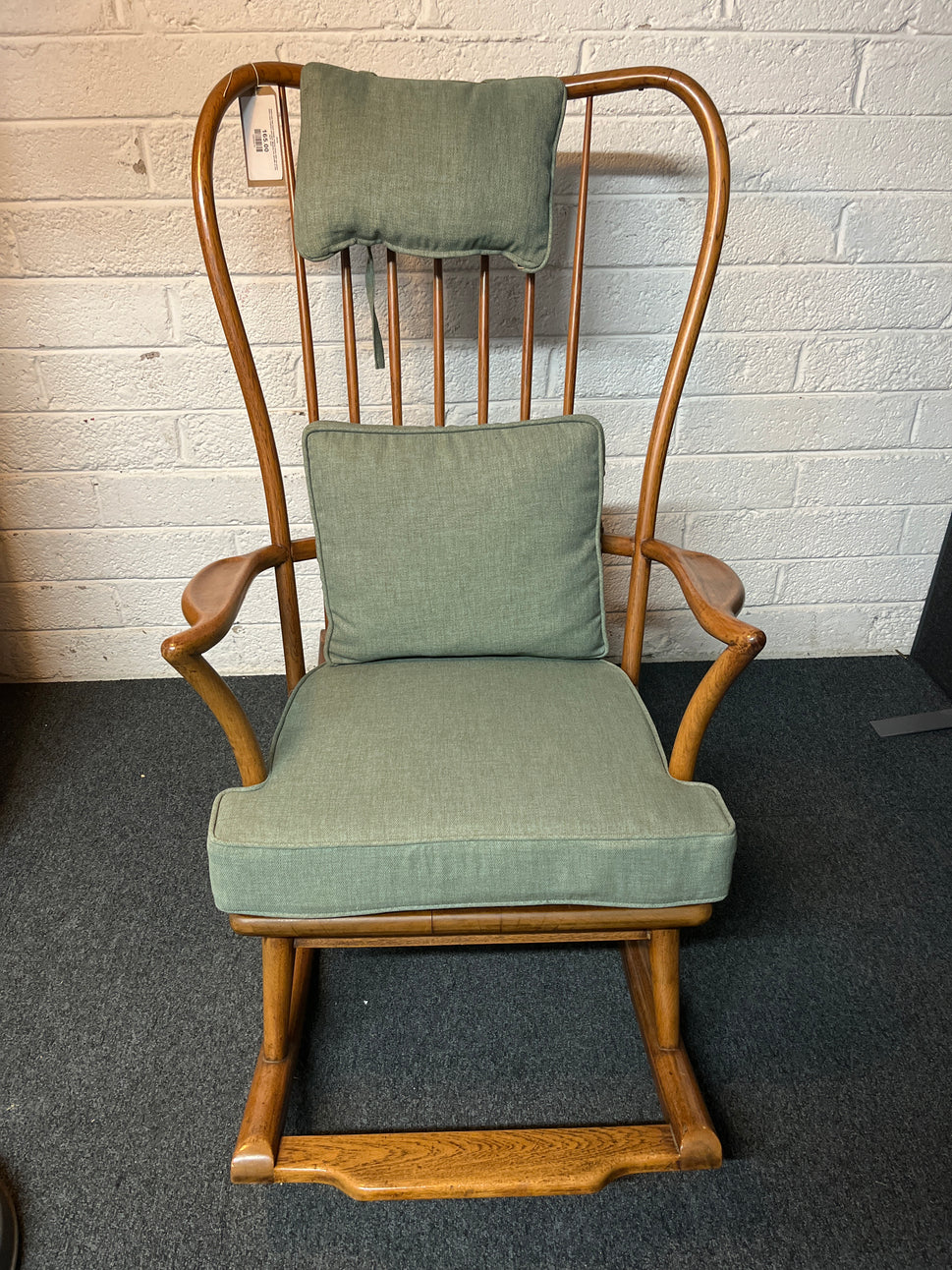 Solid oak high back ornate rocking chairs with sea green fabric seat cushion and back. Missing one spindle on the back  2225