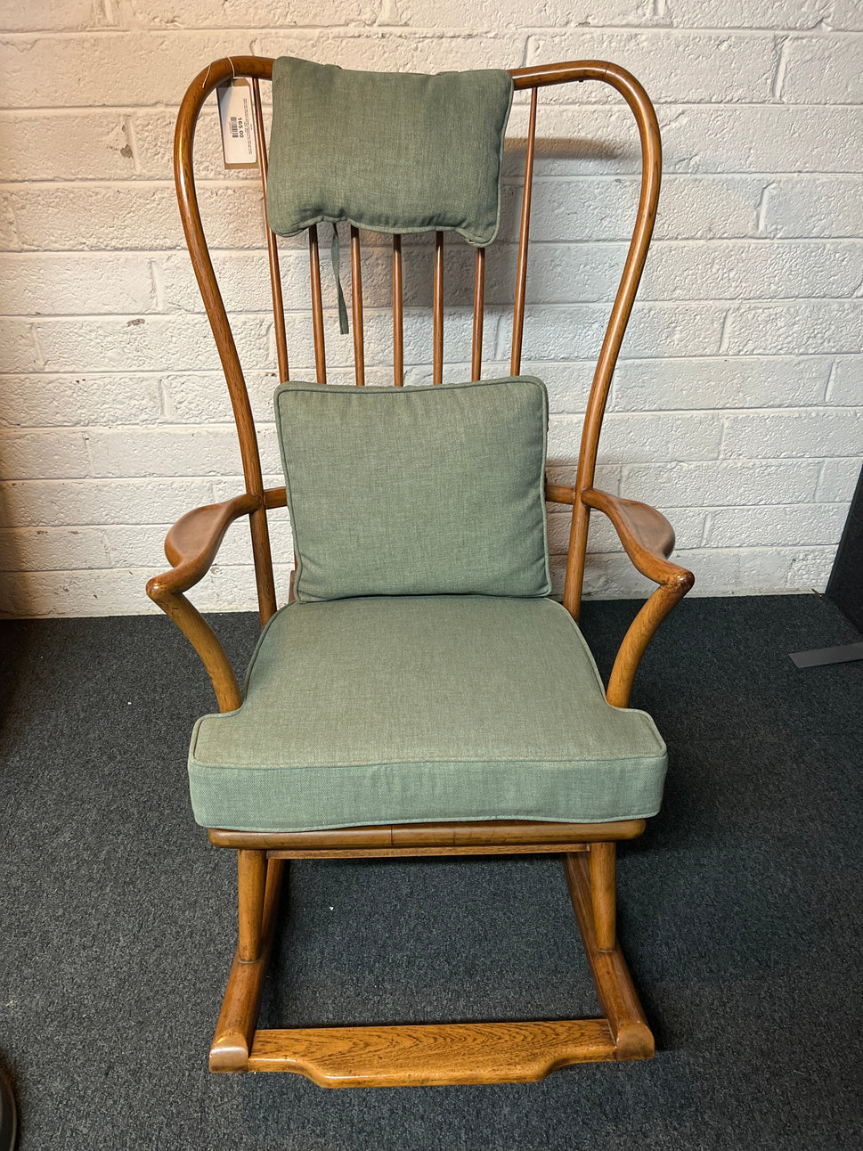 Solid oak high back ornate rocking chairs with sea green fabric seat cushion and back. Missing one spindle on the back  2225