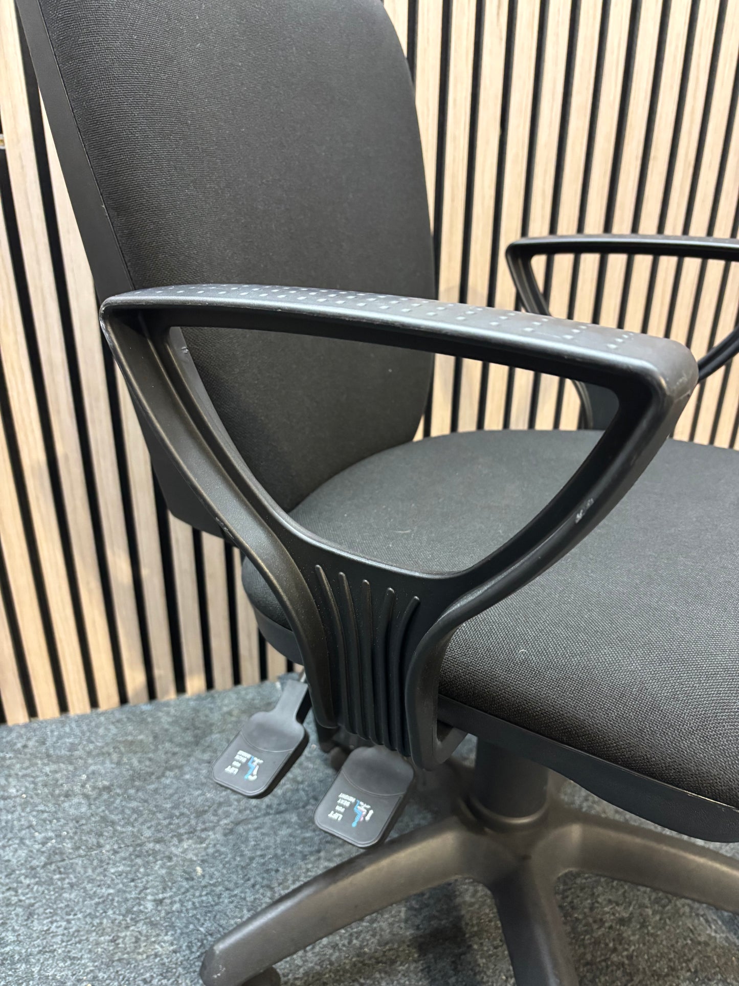 Black fabric swivel chair with black plastic fixed arms and 5 star swivel base