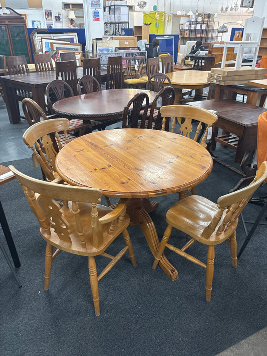 Solid pine circular kitchen table(1060 mm in diameter), central podium base with 3 no. dining chairs and 2 no. carver chairs  3125