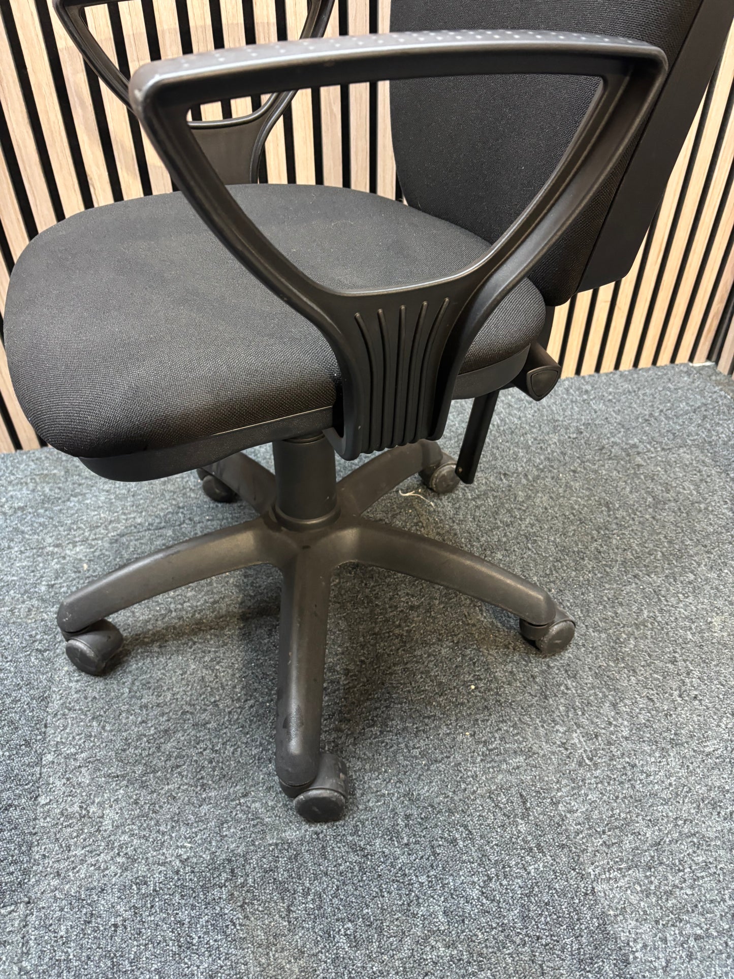 Black fabric swivel chair with black plastic fixed arms and 5 star swivel base