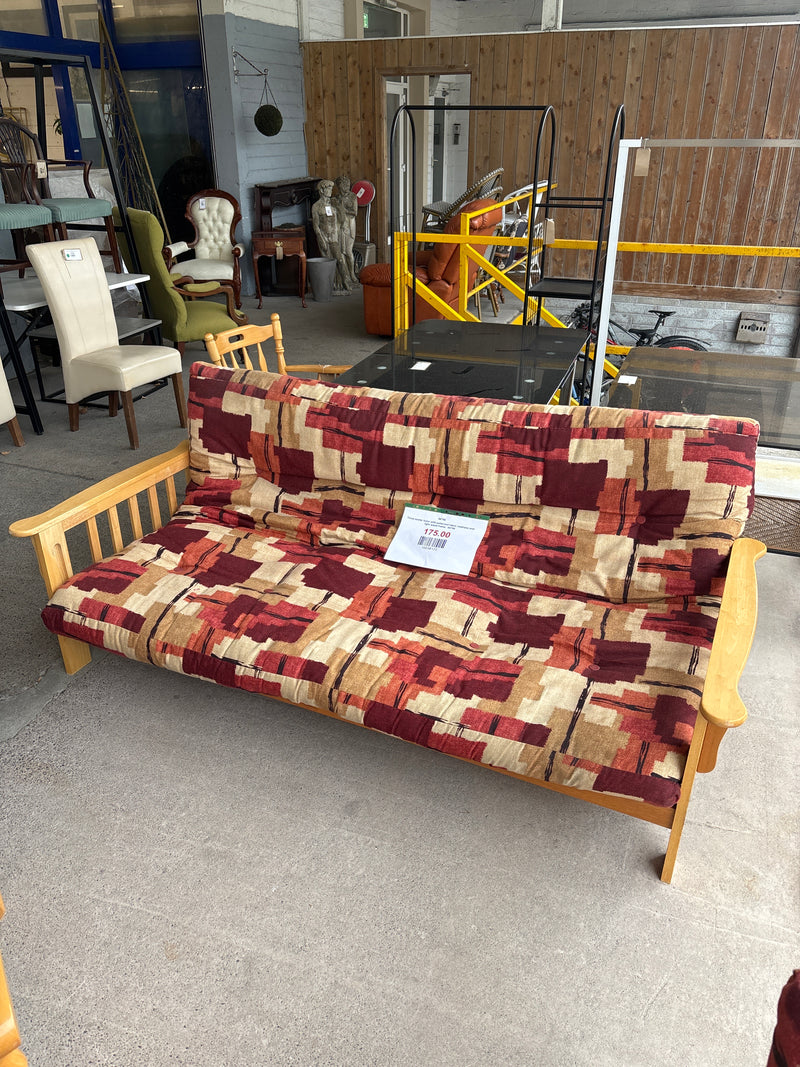 Three-seater futon with patterned fabric mattress and light wood frame.  44740