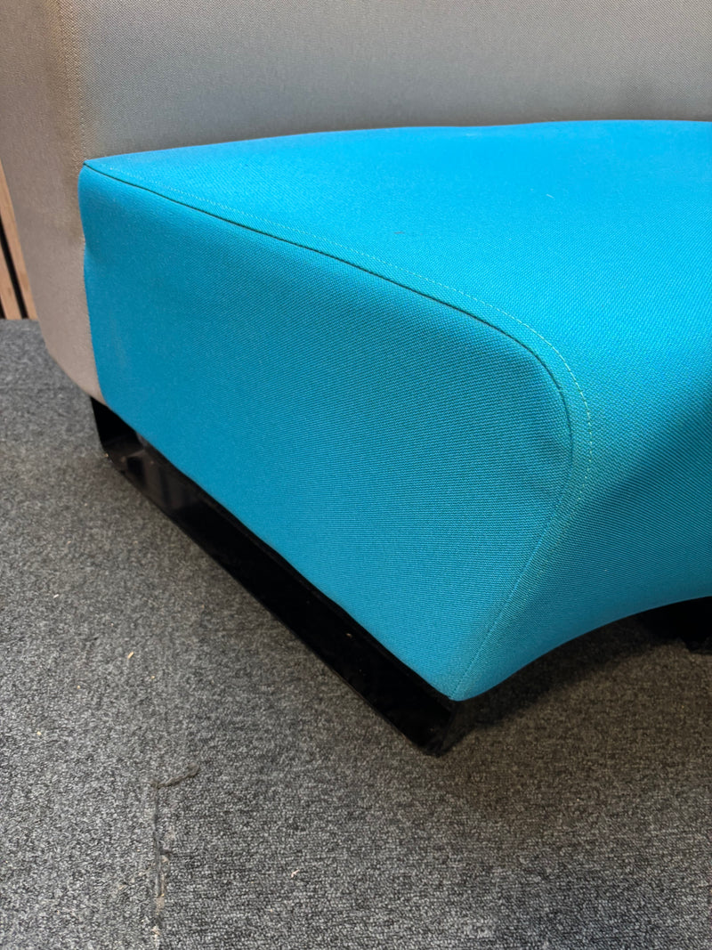 Two-piece curved fabric seating modules in grey and teal blue.