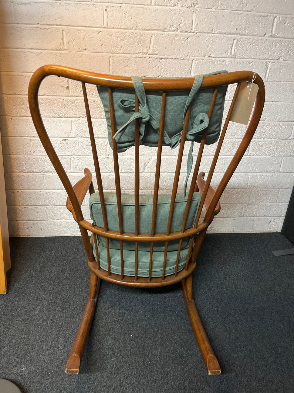 Solid oak high back ornate rocking chairs with sea green fabric seat cushion and back. Missing one spindle on the back  2225