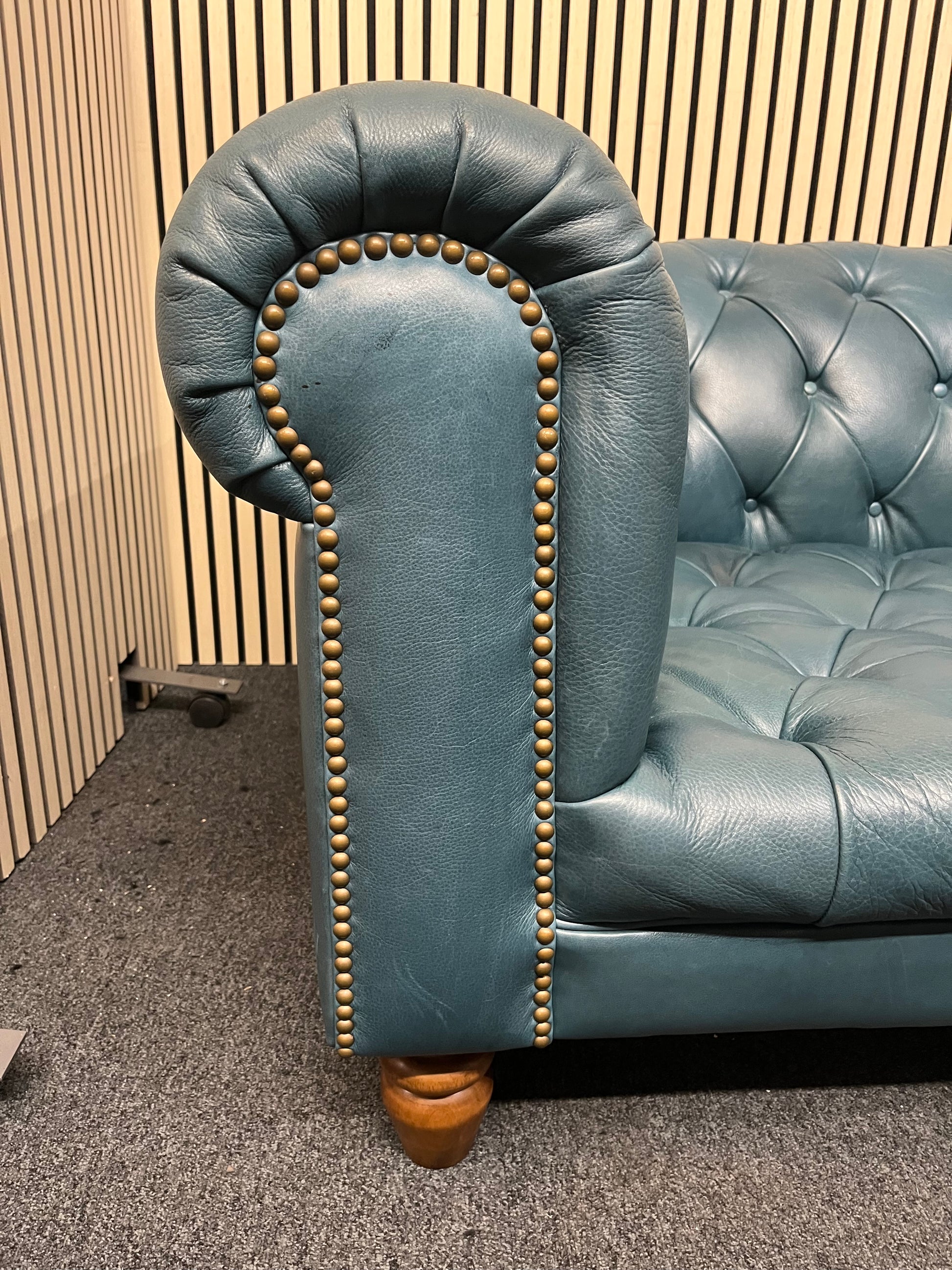 3 seater Chesterfield-style leather sofa in deep teal leather with tufted upholstery, rolled arms, and wooden legs accented by brass nailhead trim (width 230 cm) 1425