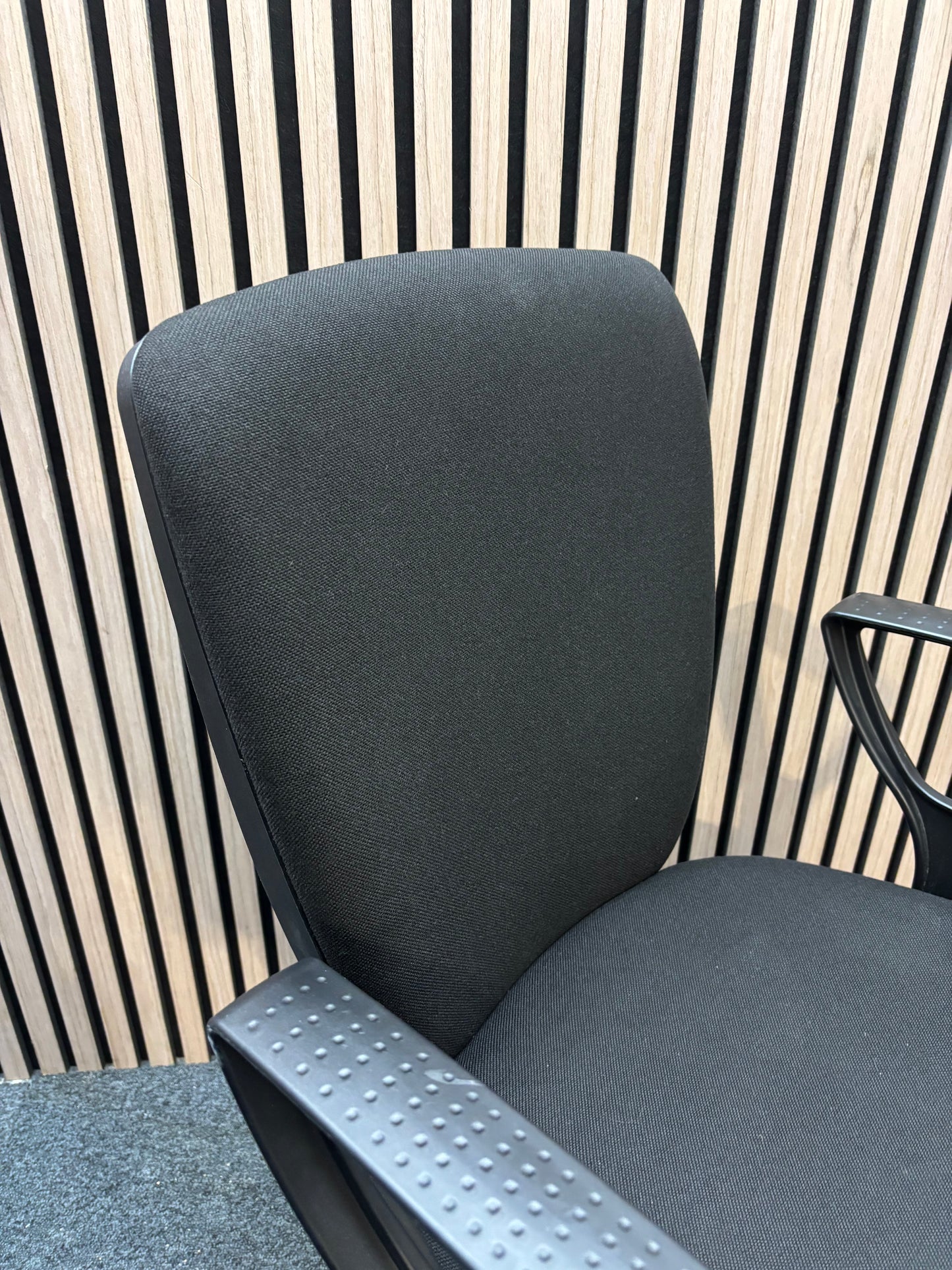 Black fabric swivel chair with black plastic fixed arms and 5 star swivel base
