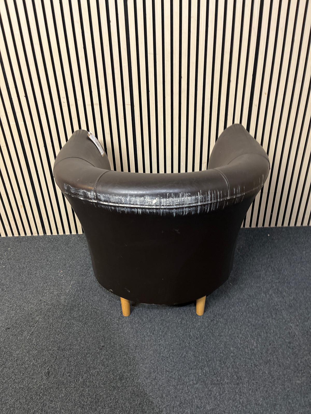 Modern curved black faux leather armchair in good condition.  44275