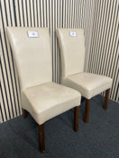 Pair of cream faux leather dining chair with dark wood legs.  44698