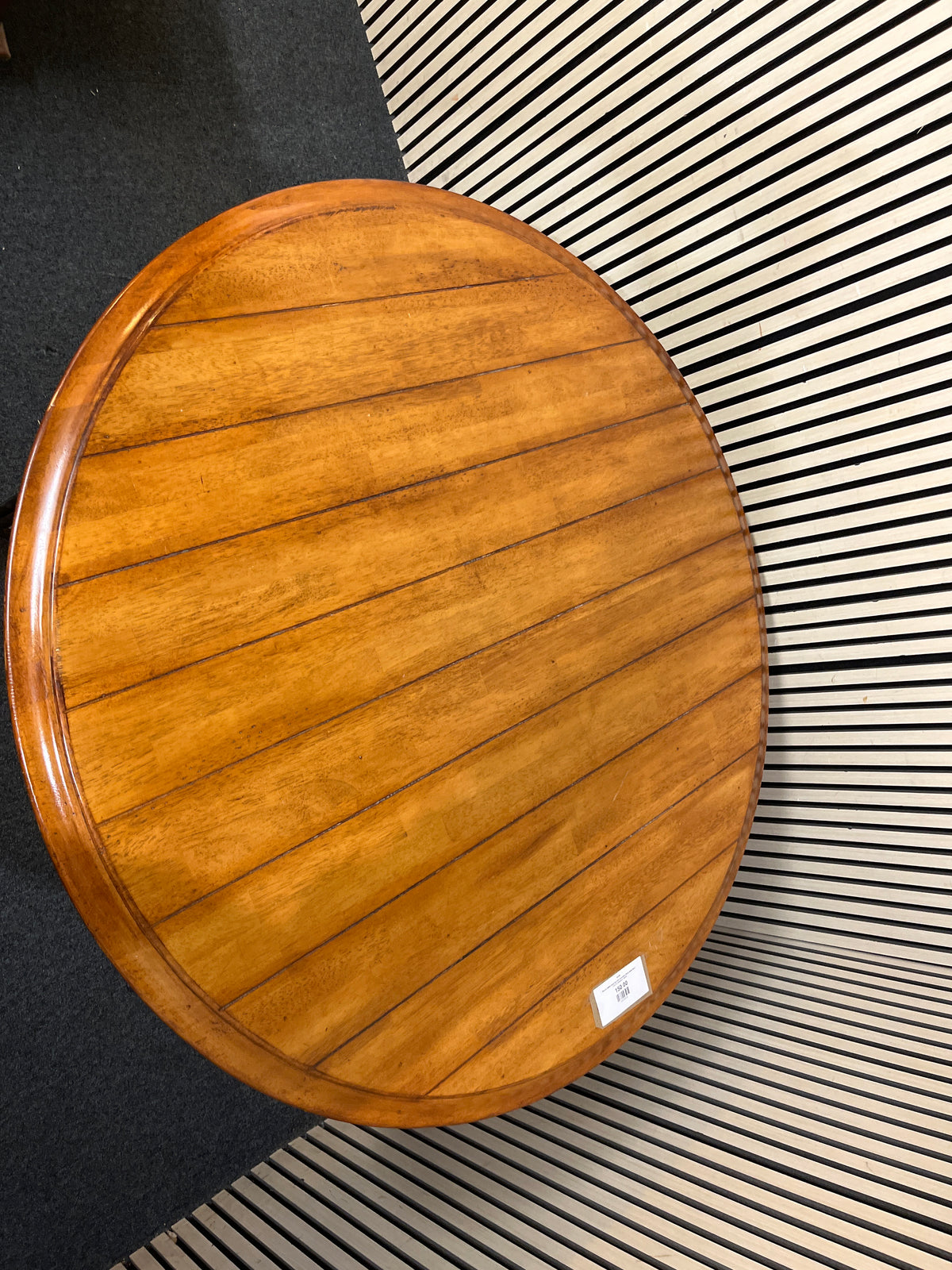Round slatted wood top with decorative black metal base.(125 cm diameter)  44256