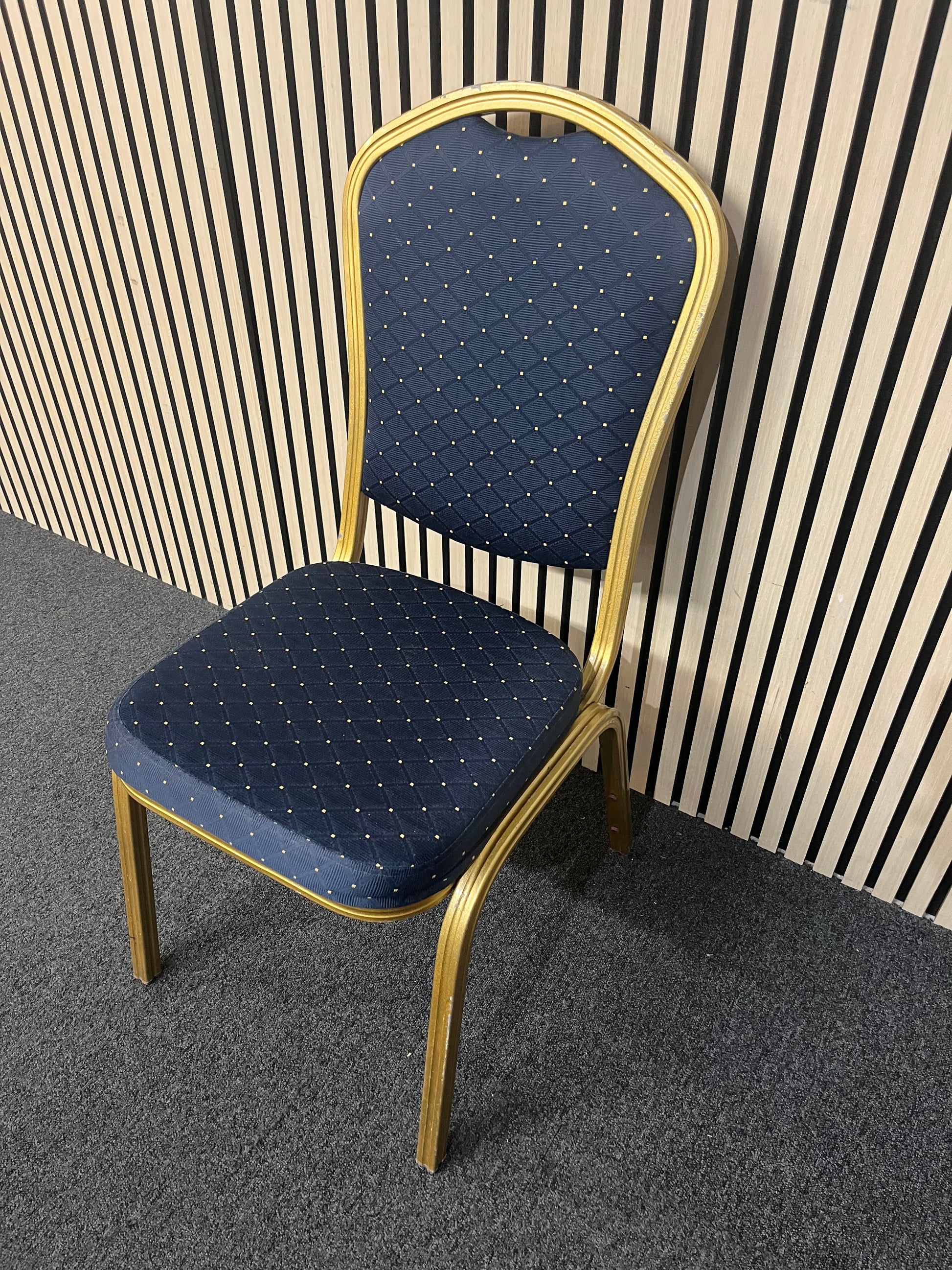 Blue patterned fabric banquet stacking chair with gold effect metal frame