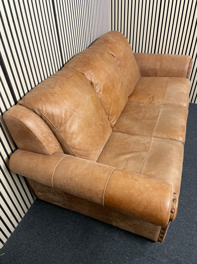 A three-seater tan leather sofa with broad, cushioned armrests W180x94D  44493