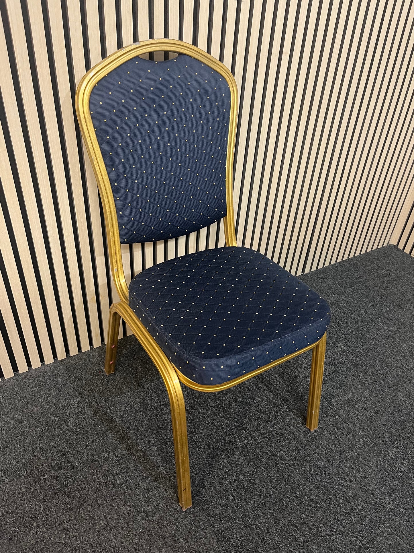 Blue patterned fabric banquet stacking chair with gold effect metal frame
