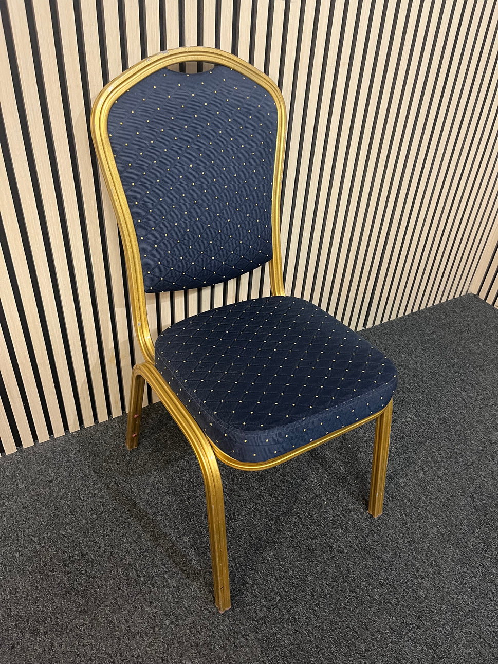Blue patterned fabric banquet stacking chair with gold effect metal frame