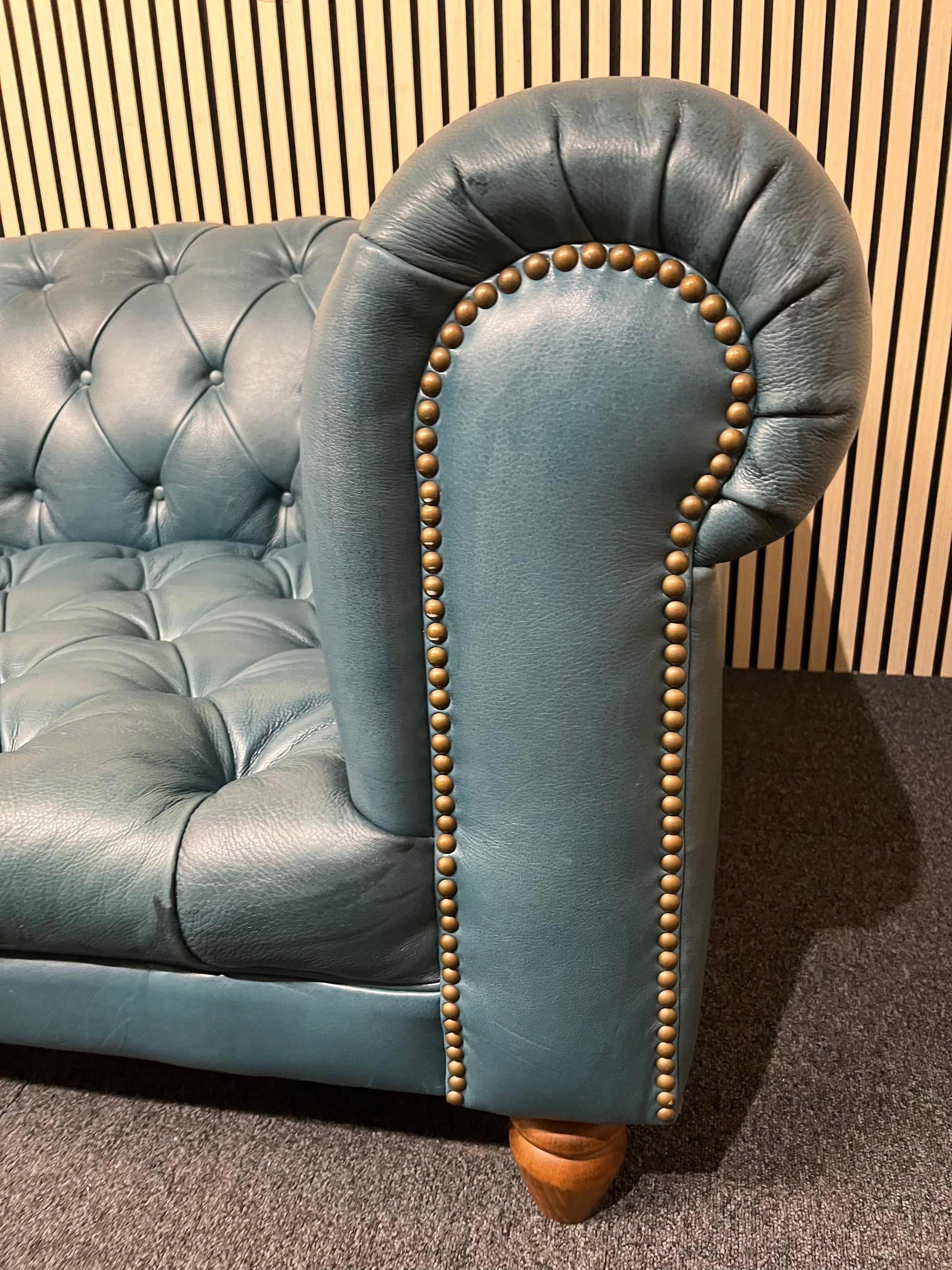 3 seater Chesterfield-style leather sofa in deep teal leather with tufted upholstery, rolled arms, and wooden legs accented by brass nailhead trim (width 230 cm) 1425