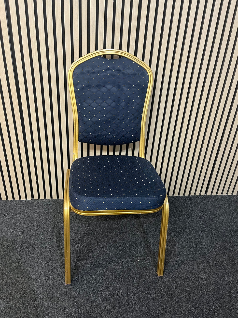 Blue patterned fabric banquet stacking chair with gold effect metal frame