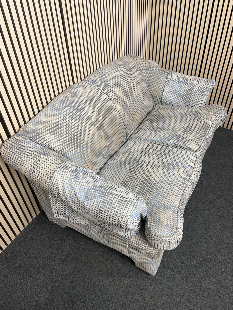 Two seater sofa with blue polka dot pattern and cushions.  44519
