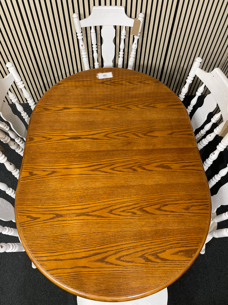 Oval wood dining table with six white spindle back chairs.  44515