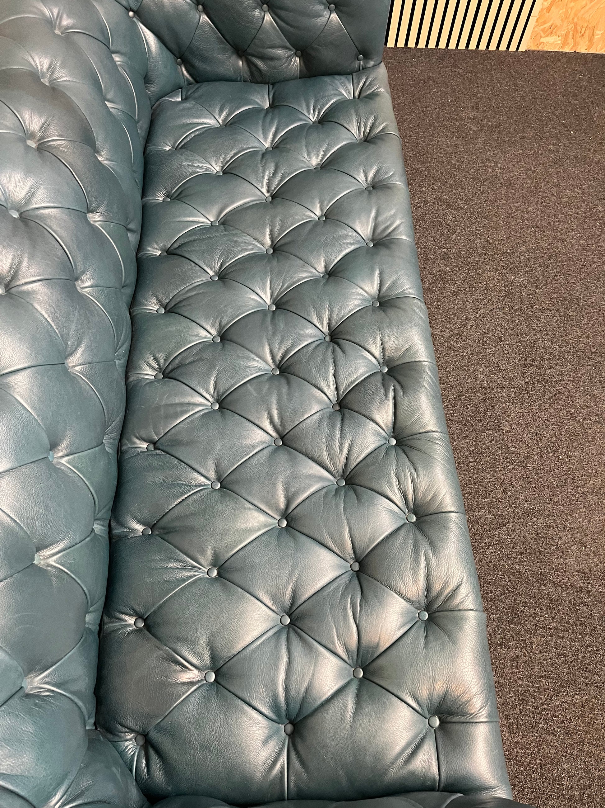 3 seater Chesterfield-style leather sofa in deep teal leather with tufted upholstery, rolled arms, and wooden legs accented by brass nailhead trim (width 230 cm) 1425