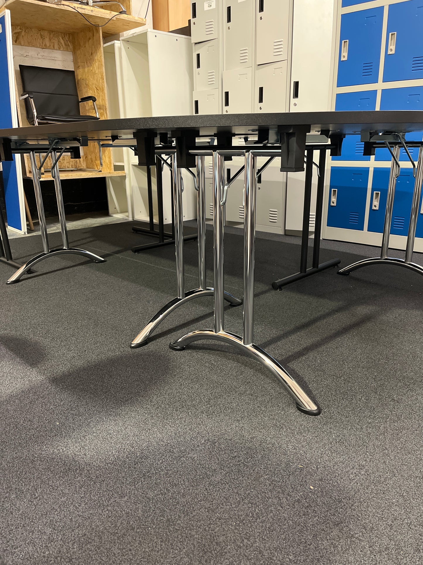 Large black oval shaped boardroom table  (length 2.8 m width 1.6 m) comprised of 2 black semi-circular foldable desks and 2 black straight foldable desks