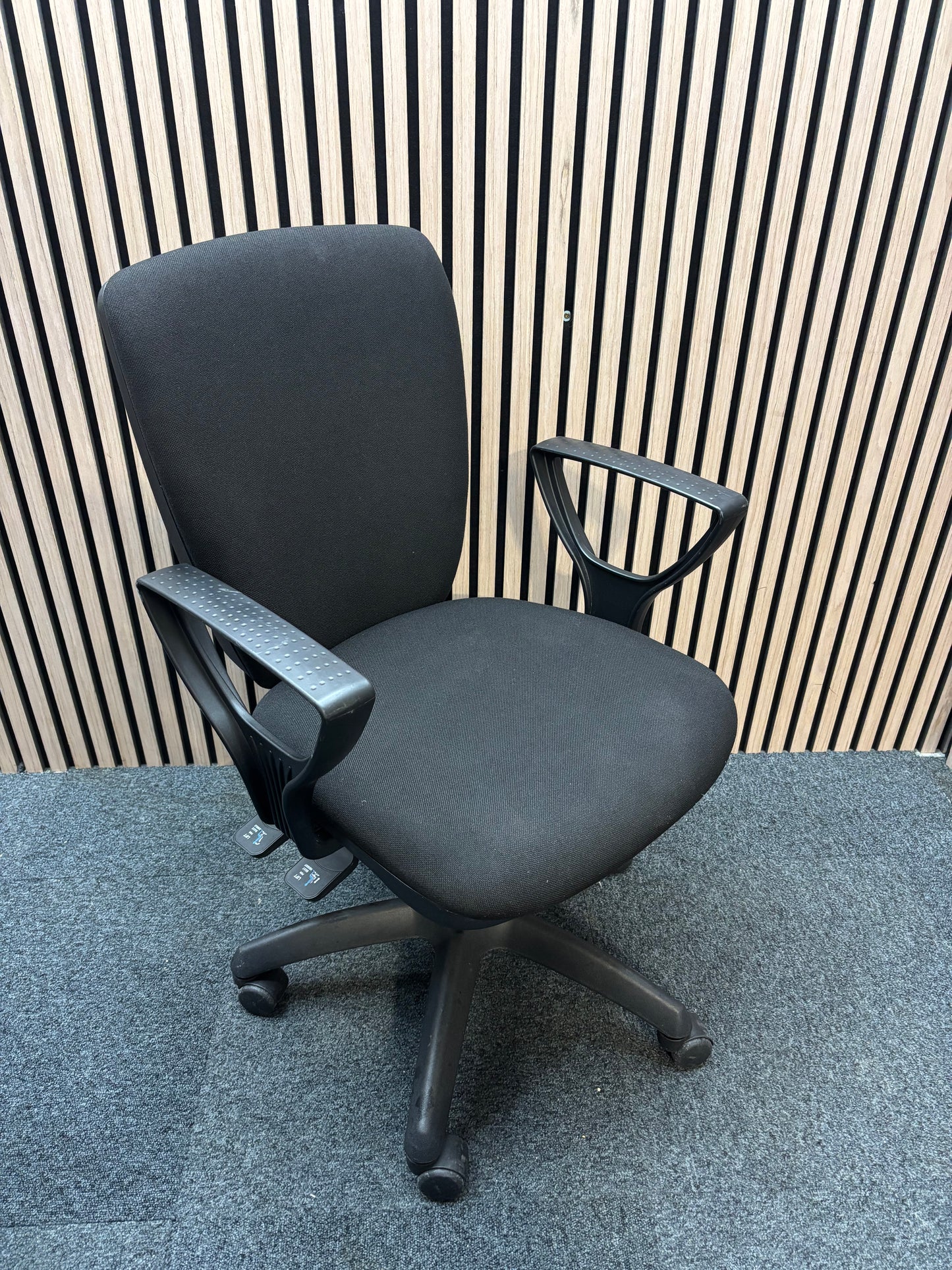 Black fabric swivel chair with black plastic fixed arms and 5 star swivel base
