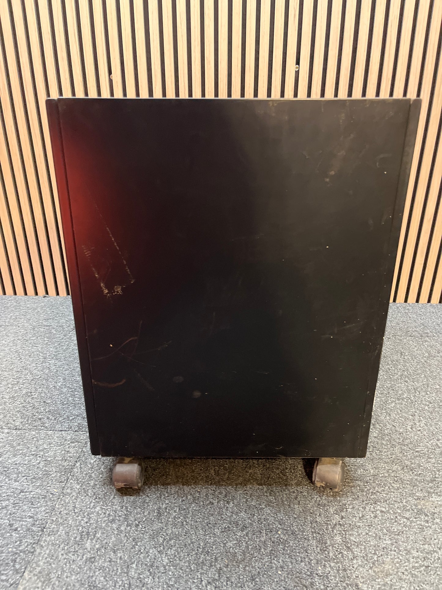 Low black laminate two door storage unit on castors (H 66 x W 70 x D 50 cm)