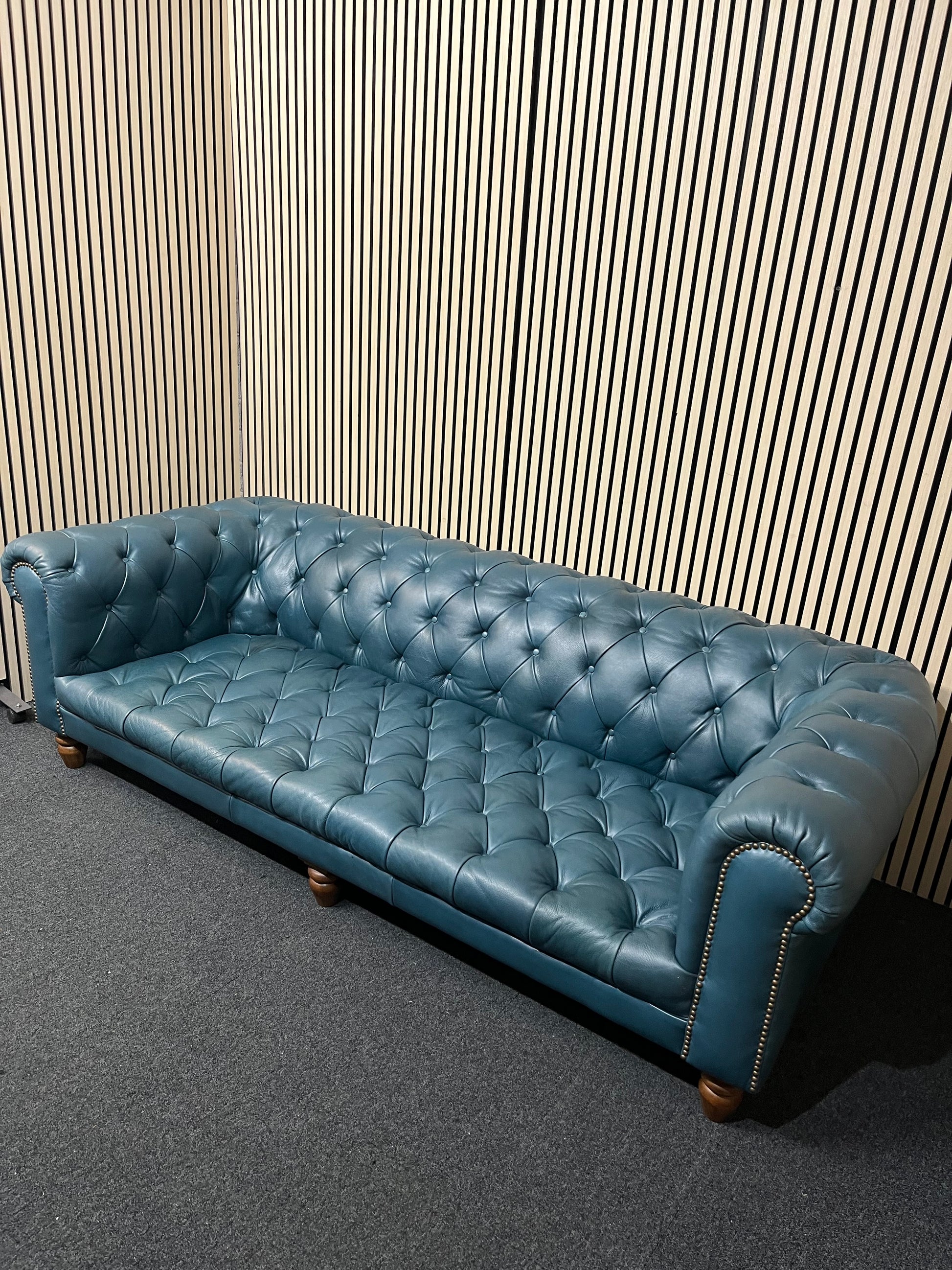 3 seater Chesterfield-style leather sofa in deep teal leather with tufted upholstery, rolled arms, and wooden legs accented by brass nailhead trim (width 230 cm) 1425
