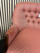 Two-seater sofa with pink geometric pattern and tufted backrest with slight wear to arm on LHS, solid wood frame. Ideal for
