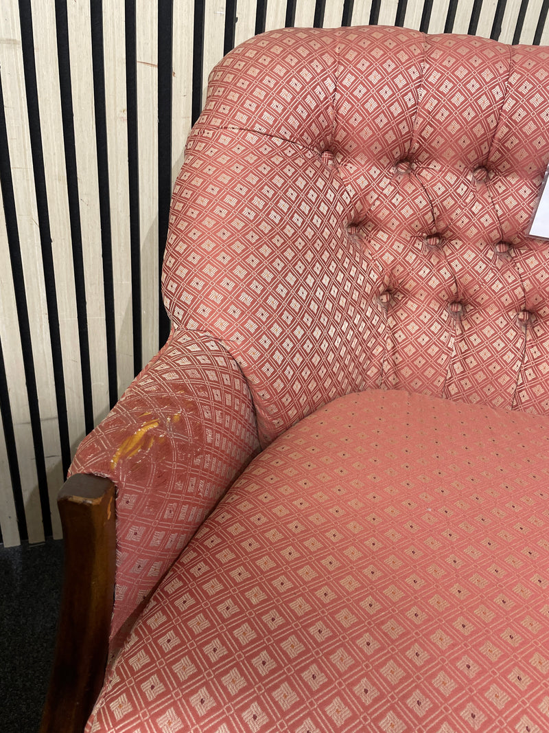 Two-seater sofa with pink geometric pattern and tufted backrest with slight wear to arm on LHS, solid wood frame. Ideal for