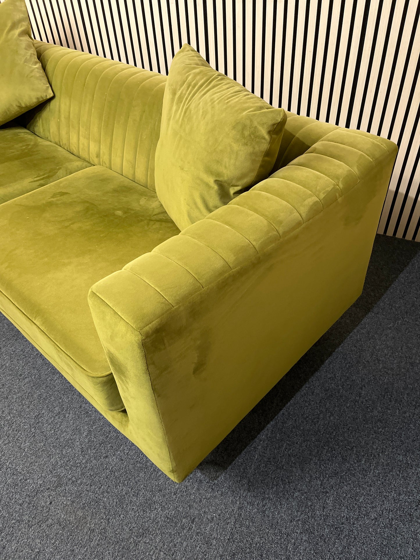 Modern olive green velvet sofa with vertical channel tufting, 2 seat cushions and slim black legs assencted with gold tips( W x 197 L x 81 H x 73 cm)
